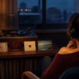 レコードを聴きながら祈り・恋・別れ・秘密・美しい島を象徴する5枚の写真を眺める女性の後ろ姿