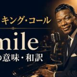 ナット・キング・コールがピアノの前でほほ笑む「Smile 歌詞の意味・和訳」のアイキャッチ