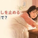 ベッドからスマートフォンの目覚ましを止める女性と「目覚ましを止める」は英語で？の文字