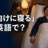 ベッドで仰向けに寝る人と「仰向けに寝るは英語で？」の文字