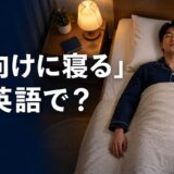 ベッドで仰向けに寝る人と「仰向けに寝るは英語で？」の文字