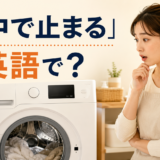 洗濯の途中で止まった洗濯機を見て驚く女性と「途中で止まる」は英語で？の文字