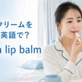 鏡を見ながらリップクリームを塗る女性とput on lip balmの英語表現