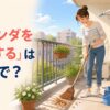 ほうきでマンションのベランダを掃除する様子