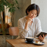 カフェでコーヒーと読書を楽しむ大人の女性