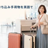 空港のチェックインカウンターで機内持ち込み手荷物・預け入れ手荷物・身の回り品を持つ女性