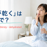 朝起きて口の乾きを感じ水を飲む女性