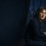 ニューヨークの夜景を背に白いピアノへ向かうジョン・レノンのイラスト