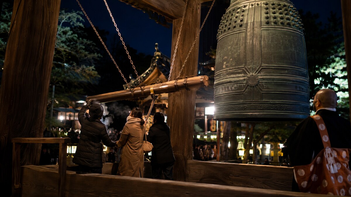 大晦日の夜に寺院の梵鐘を撞木でつく人々