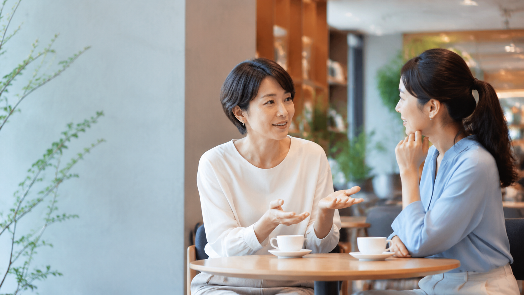 カフェで自然に会話する二人の女性