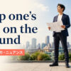 keep one’s feet on the groundの意味・使い方・ニュアンスを解説するアイキャッチ画像