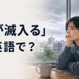 「気が滅入る」は英語で？と雨の日に気分が沈む女性のイラスト