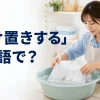 汚れたシャツを水につけ置きする女性と「つけ置きするは英語で？」の文字