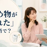 歯科医院で詰め物が取れたことを相談する女性と「詰め物が取れた」は英語で?の文字