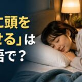 枕に頭をのせて休む人と「枕に頭をのせるは英語で?」の文字