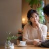 カフェで思わせぶりな態度の相手と話す大人の日本人女性