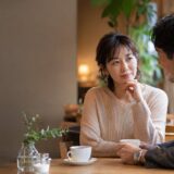 カフェで思わせぶりな態度の相手と話す大人の日本人女性