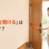 「ドアを開ける」は英語で?と書かれた、玄関のドアを開ける女性のイラスト