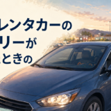 海外の駐車場でレンタカーのバッテリーが上がりロードサービスへ電話する日本人女性旅行者