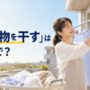 「洗濯物を干す」は英語で？ベランダで衣類を干す女性