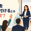 プレゼン後に質問を受け付ける女性と「質問を受け付けるは英語で？」の文字