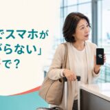 海外の空港でスマートフォンの通信不良を相談する日本人旅行者