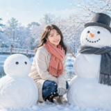 日本の2段の雪だるまと海外の3段の雪だるまを紹介する女性