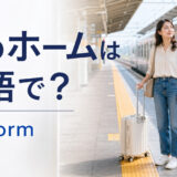 駅のホームで電車を待つ旅行者と「駅のホームは英語で？platform」の文字