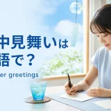 暑中見舞いのカードを書く大人の女性とSummer greetingsの英語表現