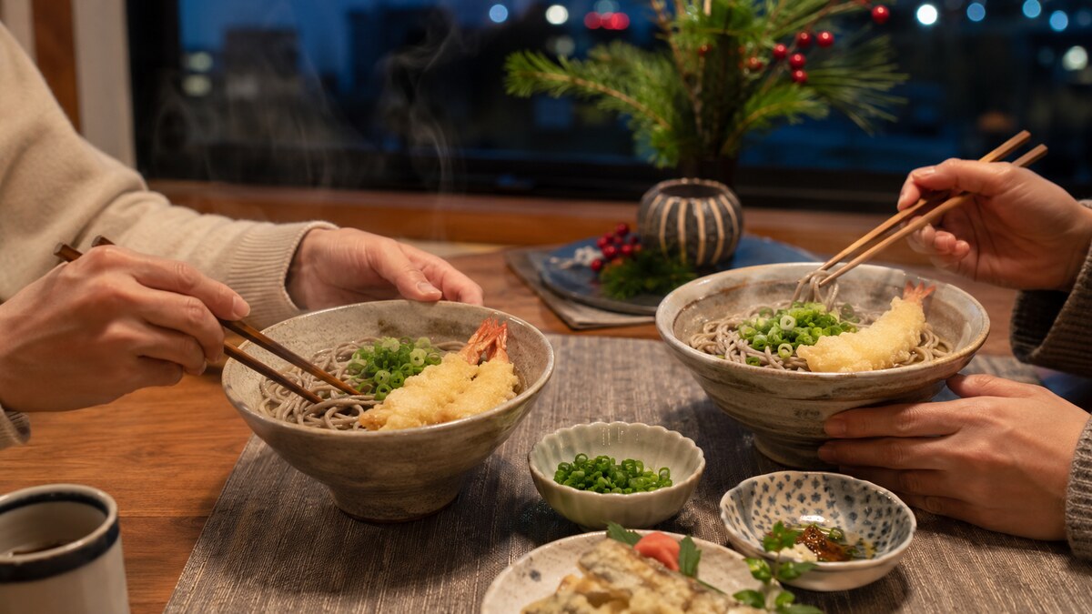大晦日の夜に家族で温かい年越しそばを食べる様子
