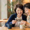 カフェで昔の写真を見ながら語り合う長年の友人