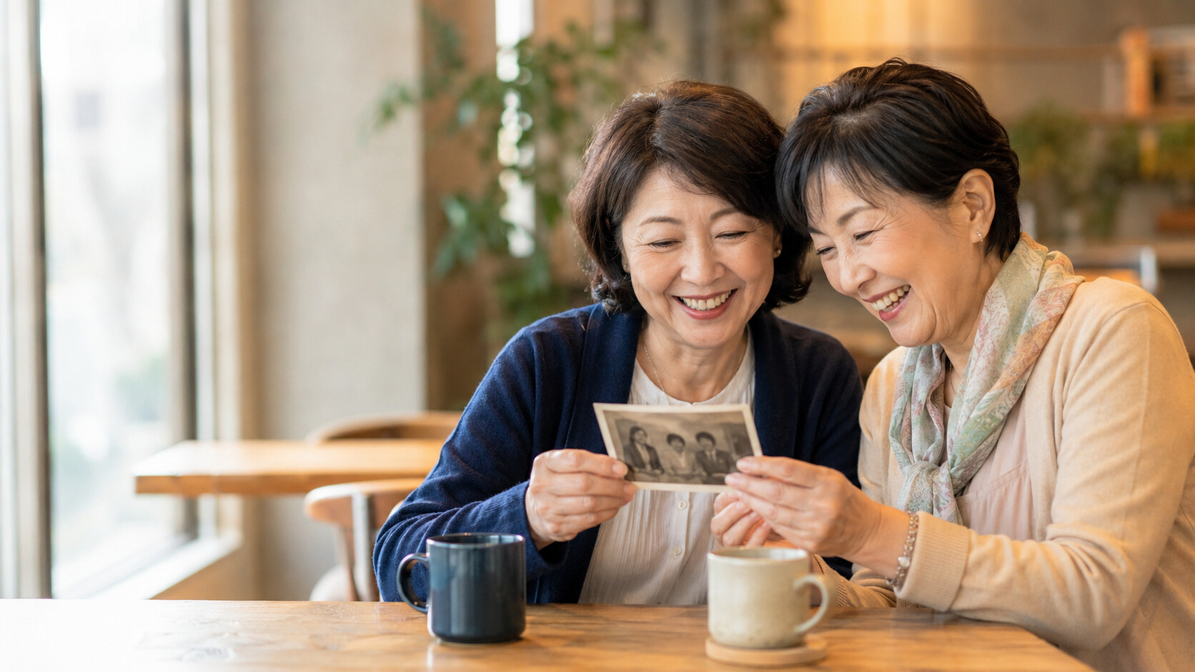 カフェで昔の写真を見ながら語り合う長年の友人