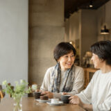 カフェで打ち解けて楽しく話す日本人女性二人