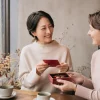 バレンタインカードとチョコレートを手に英語で会話する大人の女性たち